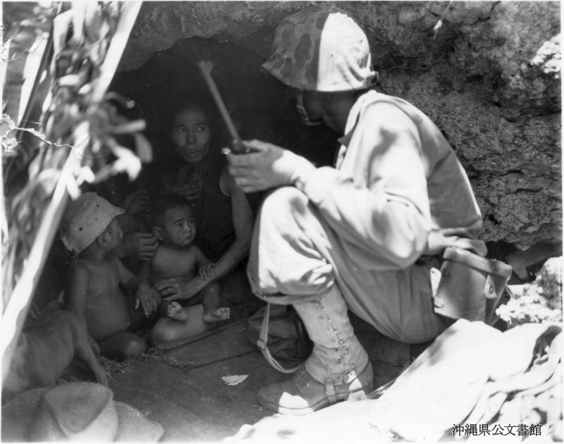 ＜壕に隠れていた女性と二人の子供を見つけた米兵（沖縄県公文書館所蔵）＞