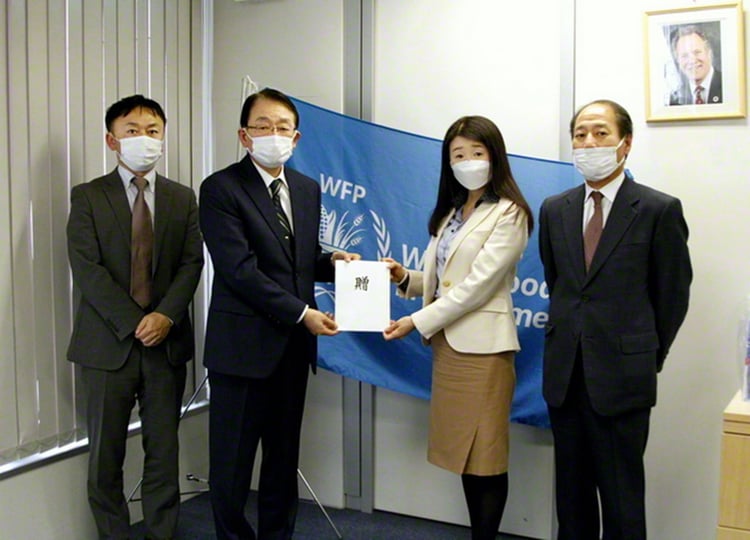 国連WFP日本事務所の焼家代表（右から2人目）に、寺崎副会長が寄付の目録を手渡す（東京・渋谷区の国連WFP東京出張所で）