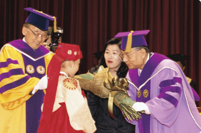 画像:授与式で民族衣装を着た少女から花束の贈呈
（1998年５月）
