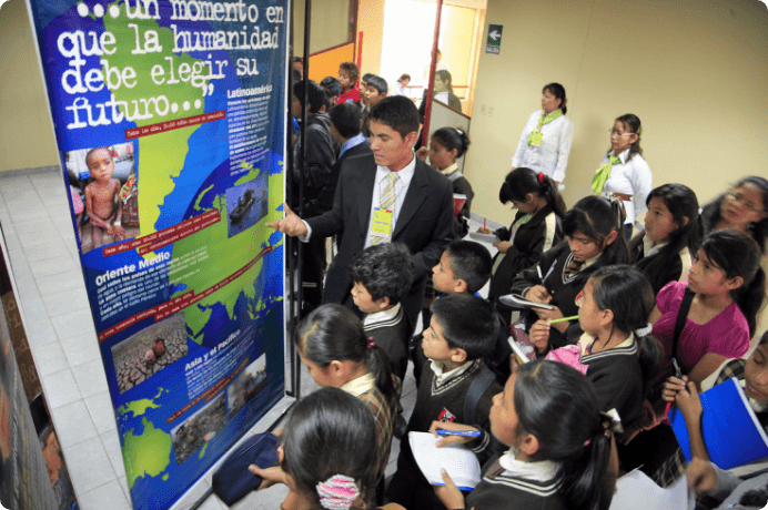 画像:SGIが地球憲章委員会と共同制作した環境展「変革の種子――地球憲章と人間の可能性」。地元の小学生や中学生が多数訪れた南米ペルーでの展示（2011年6月、リマ市内）のように、各地で世代と世代をつなぐ環境教育の場ともなってきた