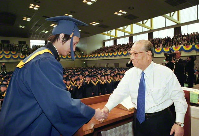 画像　創価学園の卒業式で卒業生と握手を交わす。創立者として愛する学園生の成長を信じ見守り、励まし続けてきた（2003年3月、東京・小平市で）