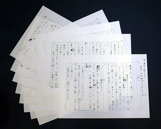 画像・何枚もの原稿用紙が重ねられている。香峯子夫人が口述筆記した人間革命の原稿