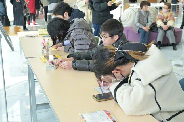 画像　能登半島地震で被災された方へエールをつづる様子